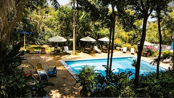 Una piscina al aire libre, sillones reclinables de piscina