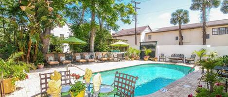 Alberca al aire libre, sombrillas en la alberca y camastros