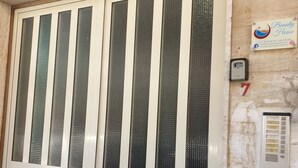 A double door with vertical glass panels, a number "7" sign, and a plaque for "Beauty House". - Beauty house (Reggio Calabria)