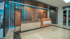 A reception desk with a wooden finish and a sign that reads "OYO". - OYO Flagship 728 Baileys Apartment (South Tangerang)