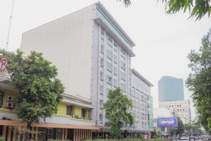 A multi-story building with a flat facade, large windows, and a sign indicating a no parking zone.