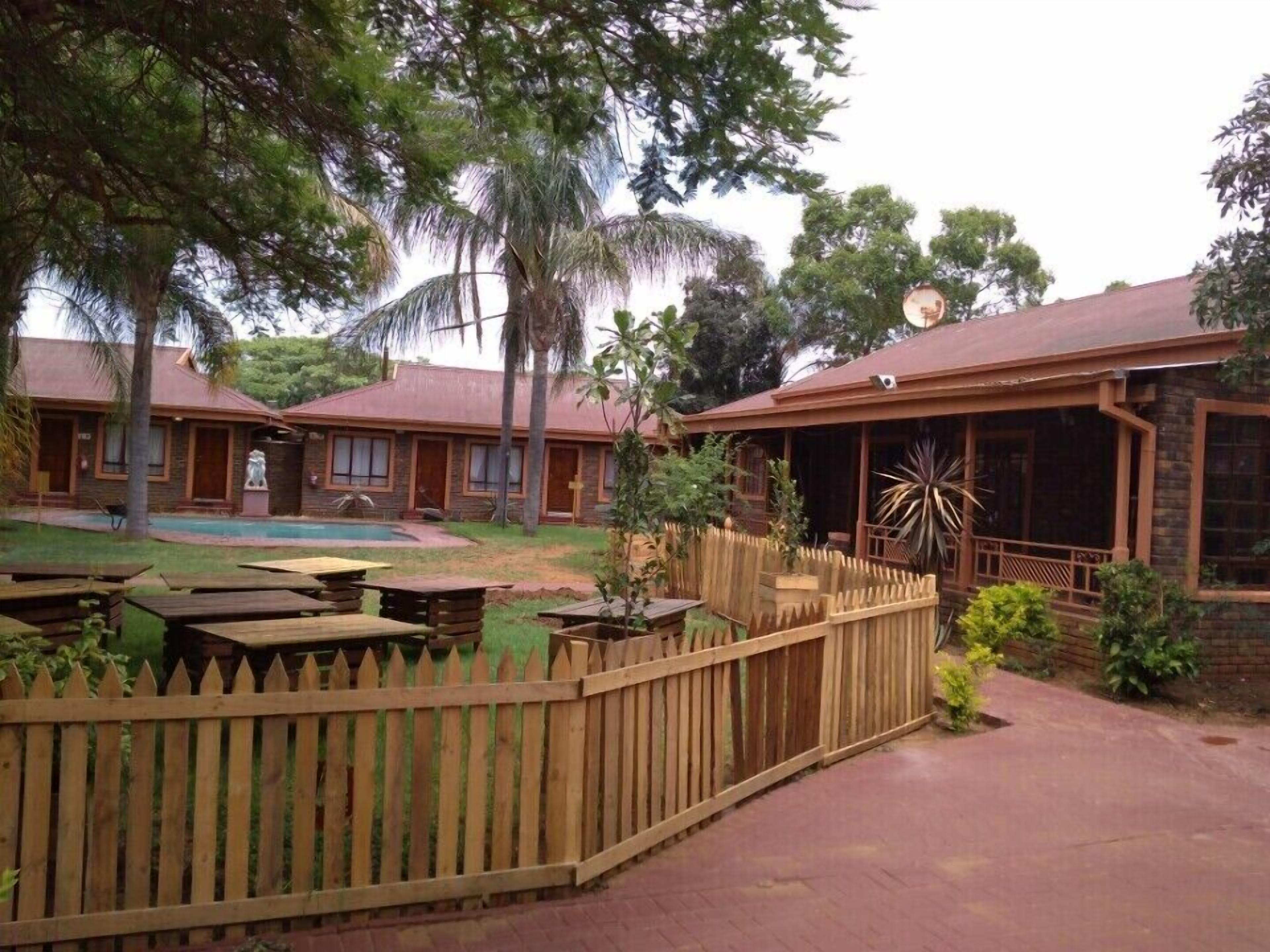 Un complexe hôtelier comprenant plusieurs chalets en bois, une piscine et un jardin clos.