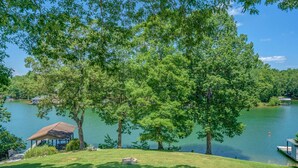 Una proprietà sul lago con un gazebo, un molo e una zona verde.