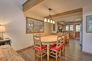 A dining area with a wooden table and chairs, a hanging light fixture, and a map on the wall. - Walk to Lift: Townhome w/ Shuttle in Breckenridge! (Breckenridge)