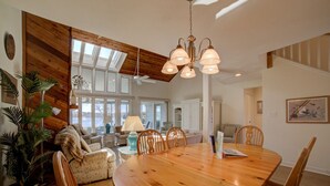 A spacious dining area with a wooden table and chairs, a chandelier, and large windows allowing natural light. - Meadows - Townhome in Bernard`s Landing with all the amenities to enjoy! (Moneta)