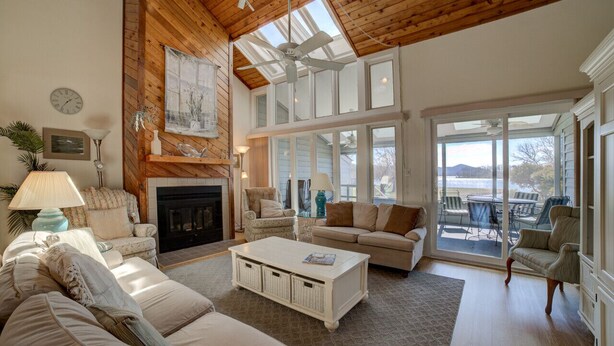 A spacious living room with a fireplace, comfortable seating, and large windows offering a view of the outdoors. - Meadows - Townhome in Bernard`s Landing with all the amenities to enjoy! (Moneta)