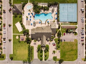 Relax by the central pool surrounded by lounge areas and a tennis court.