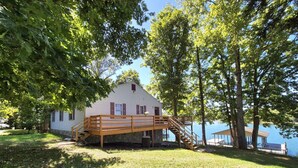 A house with a wooden deck and stairs leading to a dock by a lake. - Gus`s Getaway- Dog friendly home with huge dock with electricity - pool table and old school juke box (Huddleston)
