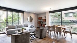 A modern living room with a sofa, coffee table, and dining area. - ATTIK STUNNING SUPERIOR  301 (Bogotá)