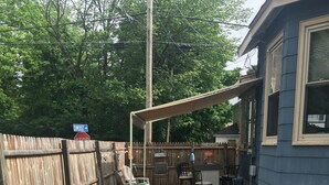 A backyard with a stone pathway leading to a covered seating area with a bar. - Beach Cottage with Outdoor Patio & Grill, 8 min. Walk to Beach (Old Orchard Beach)