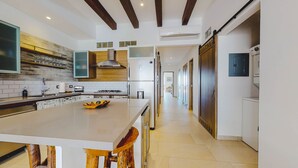 A modern kitchen with a central island, stainless steel appliances, and a wooden ceiling. - Extraordinary condo in Urban complex! 2BD Condo for rent in Old Town, Puerto val (Puerto Vallarta)