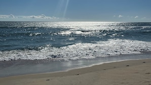 A beach with footprints in the sand and waves crashing onto the shore. - OBX Beach Box!  204 E Albatross St Milepost 10 (Nags Head)