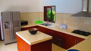 A kitchen with a refrigerator, microwave, sink, and stove.