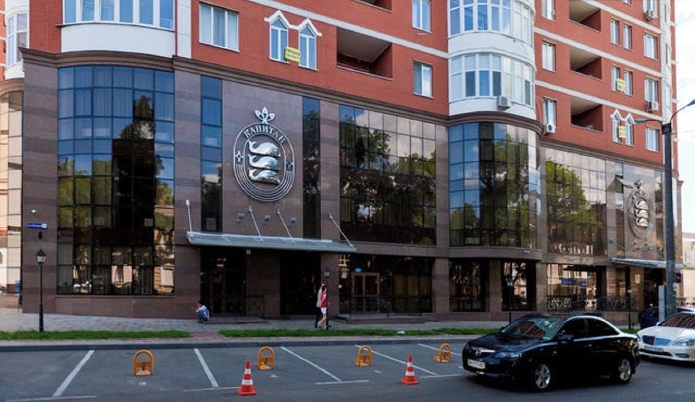 A modern hotel with a prominent logo, large glass windows, and a curved facade.