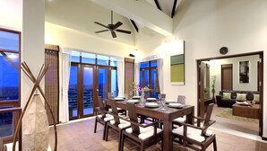 A dining area with a large table, chairs, and a ceiling fan.