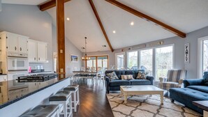 A spacious living area with a kitchen, a dining table, and a large window.