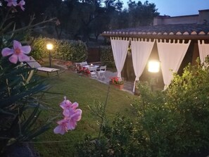 Relax in a serene outdoor space surrounded by lush greenery and beautifully maintained gardens.