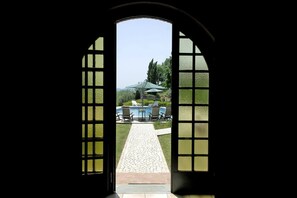 Un arco d'ingresso che conduce a una zona piscina con posti a sedere all'aperto.