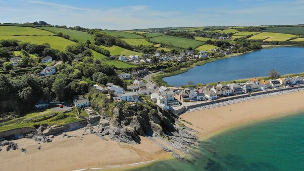 A coastal village with houses along the beach and a small harbor.