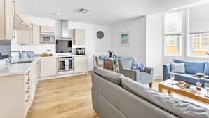 A modern apartment with a kitchen, dining area, and living room.