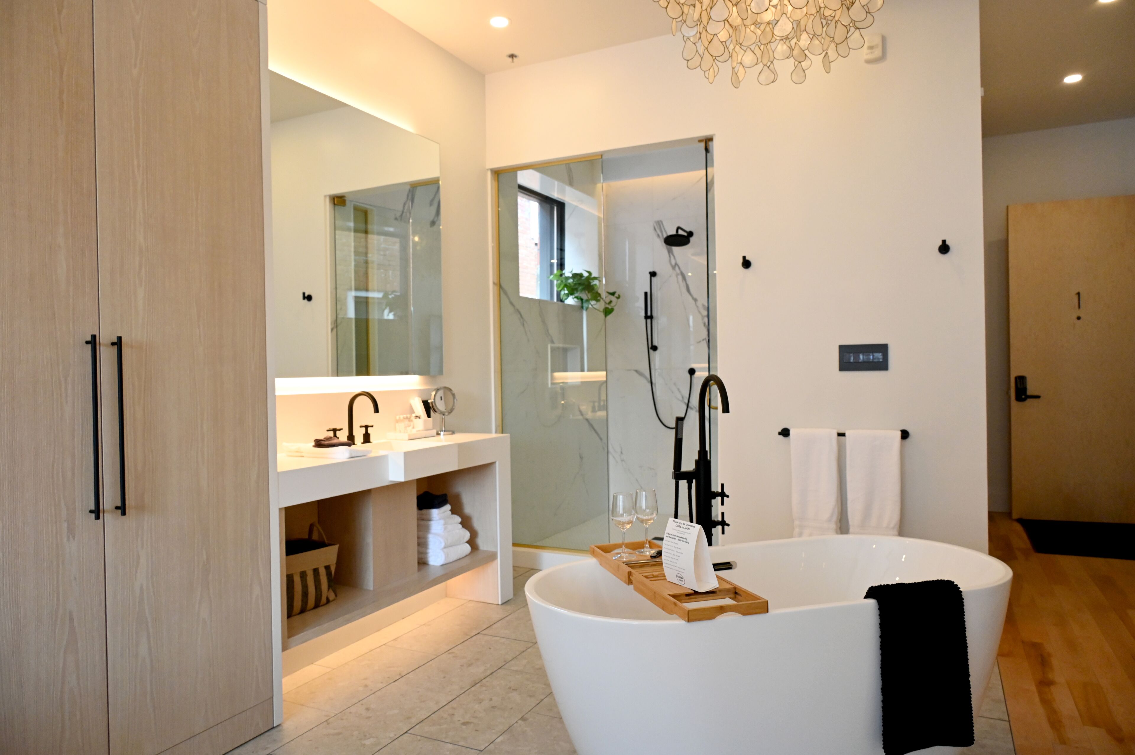 Une salle de bain moderne avec une baignoire sur pieds, une douche à parois de verre et un meuble-lavabo avec un miroir.