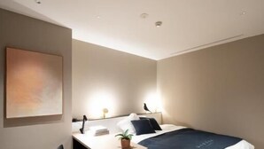 Een moderne slaapkamer met een bed, bureau en stoel.