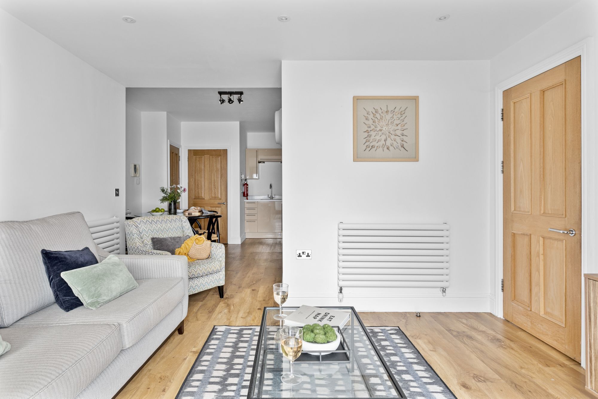 Un salon spacieux avec un canapé, une table basse et un coin repas à l’arrière-plan.