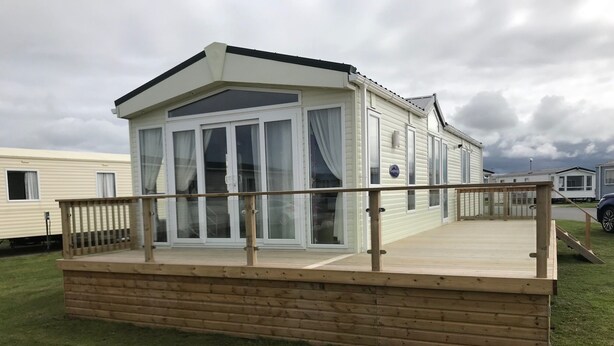 A mobile home with a deck and large windows. - Brand new luxury holiday home in one of the best holiday parks in the country. (Perranporth)