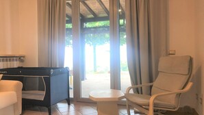 A room with a bed, a chair, a small table, and a window with curtains. - Colline Toscane, beautiful two-room apartment for 2/4 people, lovely view and swimming pool (Casole d’elsa, siena)