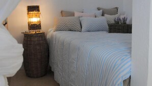 Un dormitorio con cama, lámpara y una pequeña alfombra.