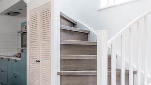 Una escalera con barandillas blancas y escalones de madera que conducen a una plataforma.