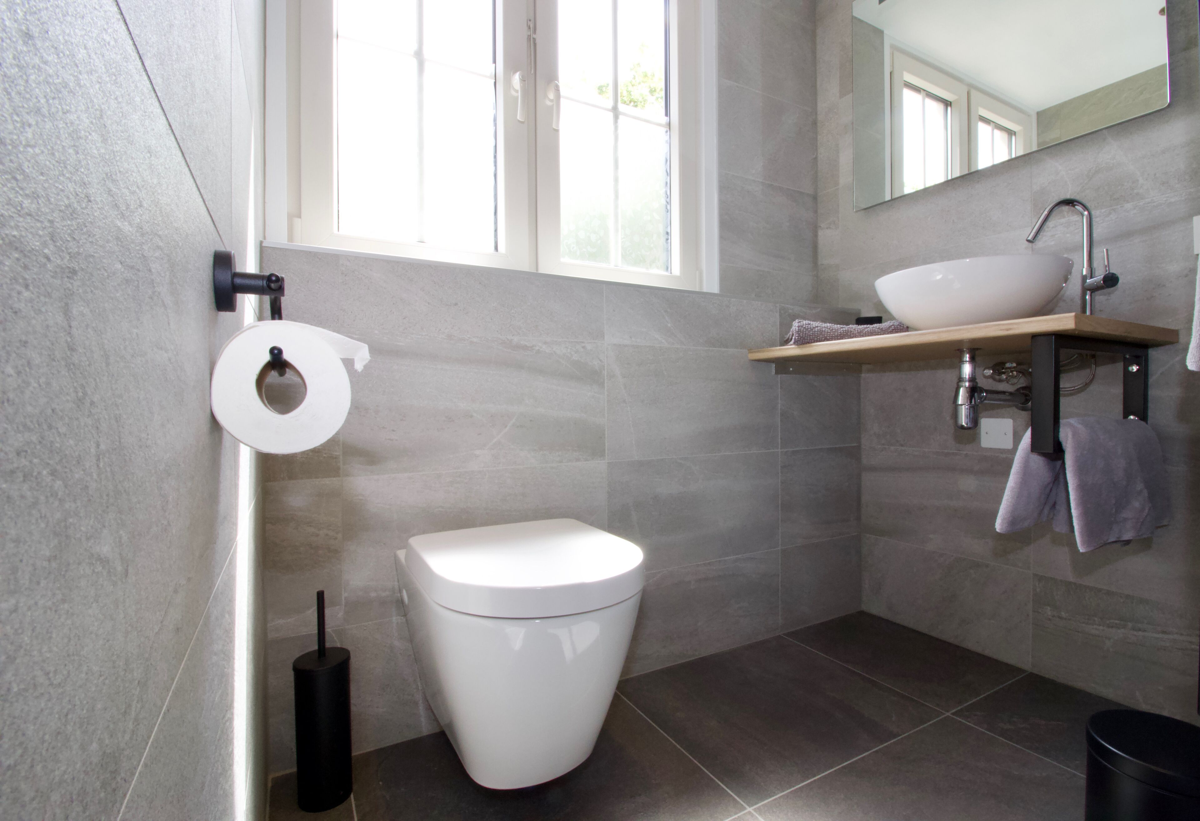 Une salle de bain moderne équipée de toilettes, d’un lavabo et d’un miroir.