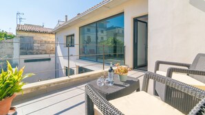 A balcony with wicker furniture, a potted plant, and a bottle of water. - MARTE - Chalet with terrace in Sa Pobla. Free WiFi (Sa Pobla)