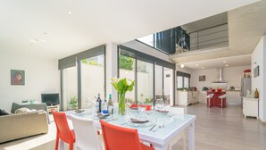 A modern dining area with a glass table, red chairs, and a kitchen in the background. - MARTE - Chalet with terrace in Sa Pobla. Free WiFi (Sa Pobla)