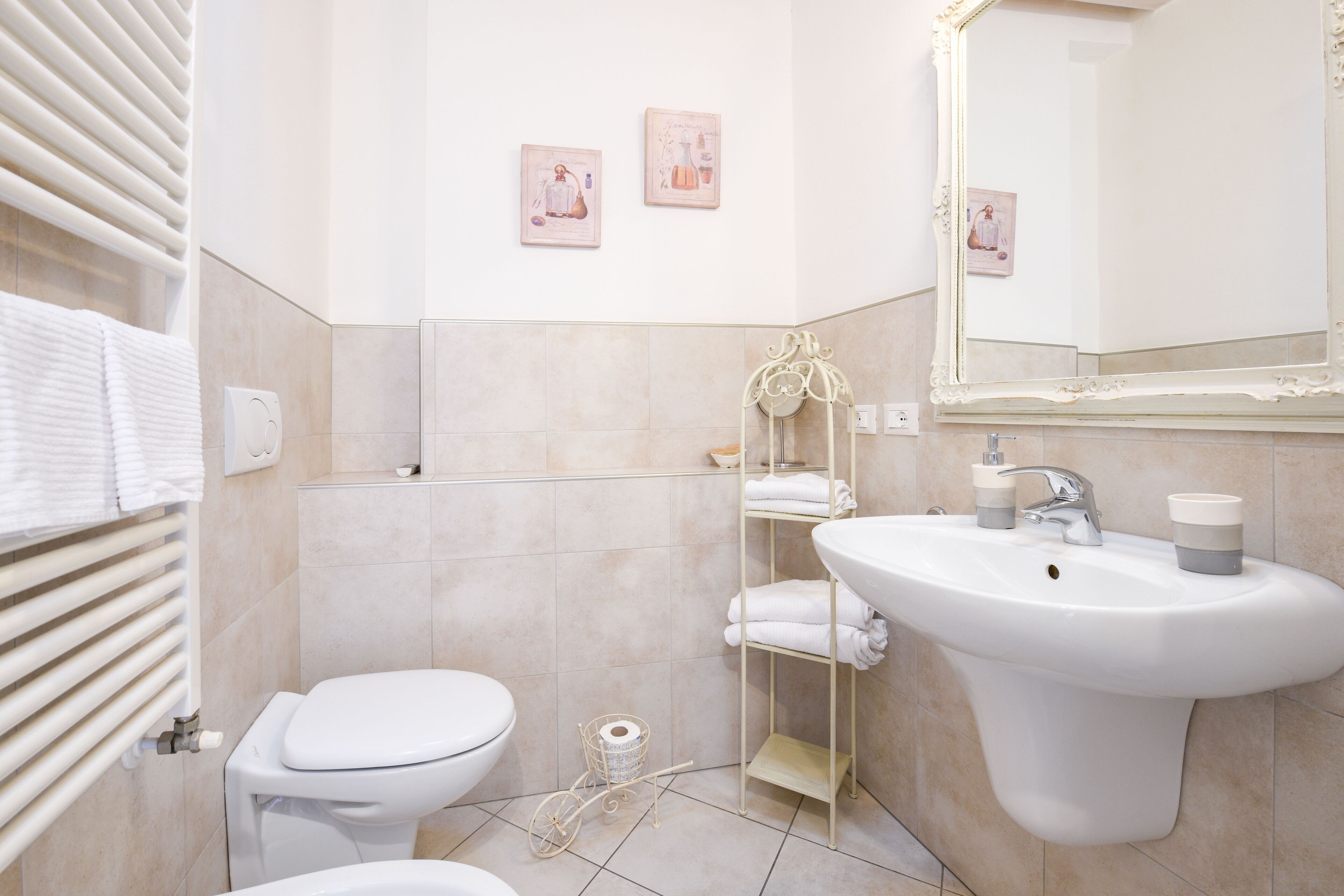 Une salle de bain équipée de toilettes, d’un lavabo et d’un porte-serviettes.