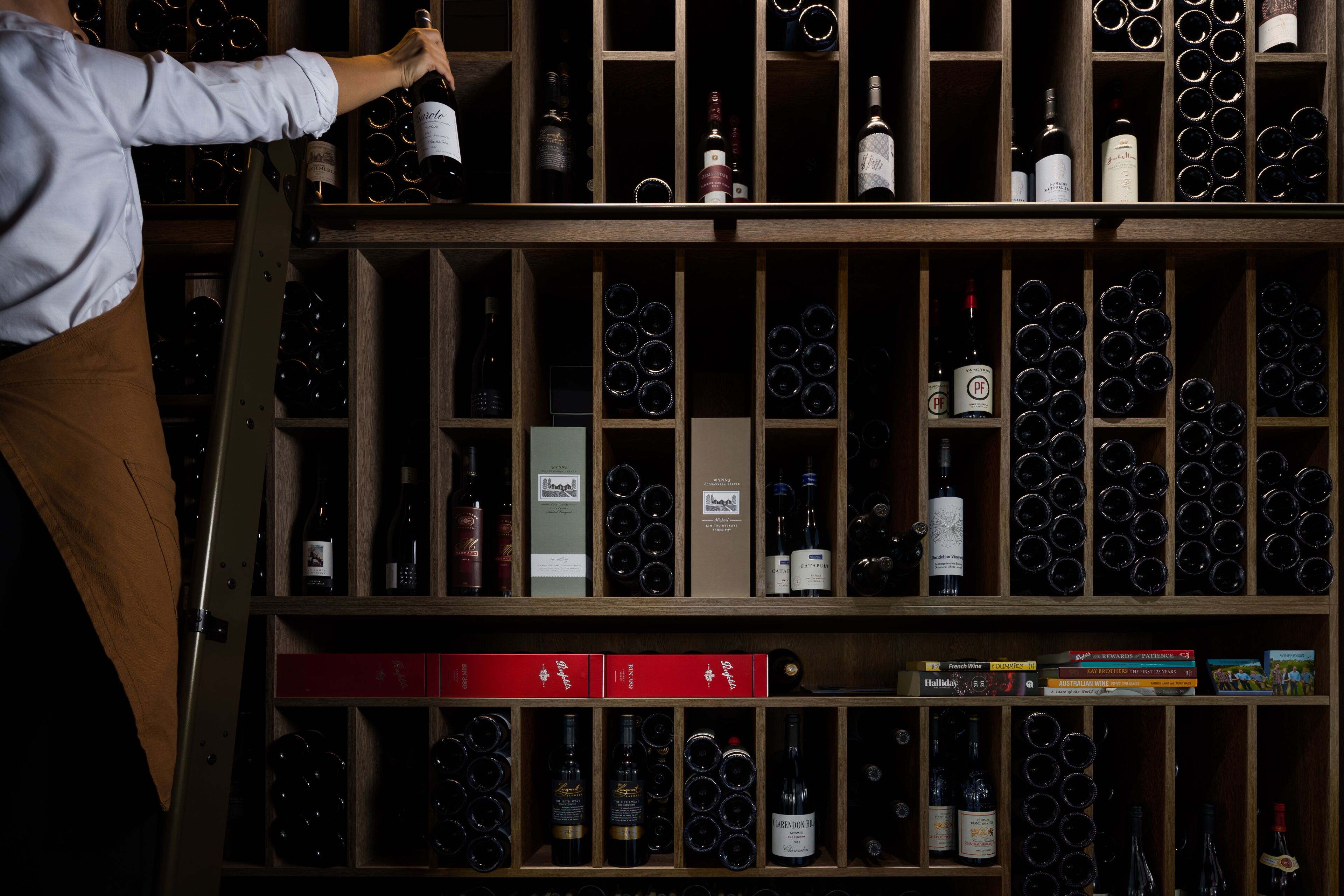 A wine cellar with shelves of wine bottles and boxes.