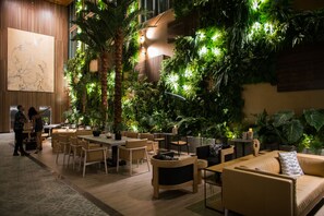 Un espace intérieur moderne comprenant un coin repas, des sièges et un grand mur végétalisé.