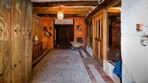 Passadís estret amb bigues de fusta i una catifes amb dibuixos.