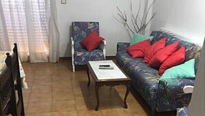 Un soggiorno con divano, poltrona, tavolino da caffè e tavolo da pranzo.
