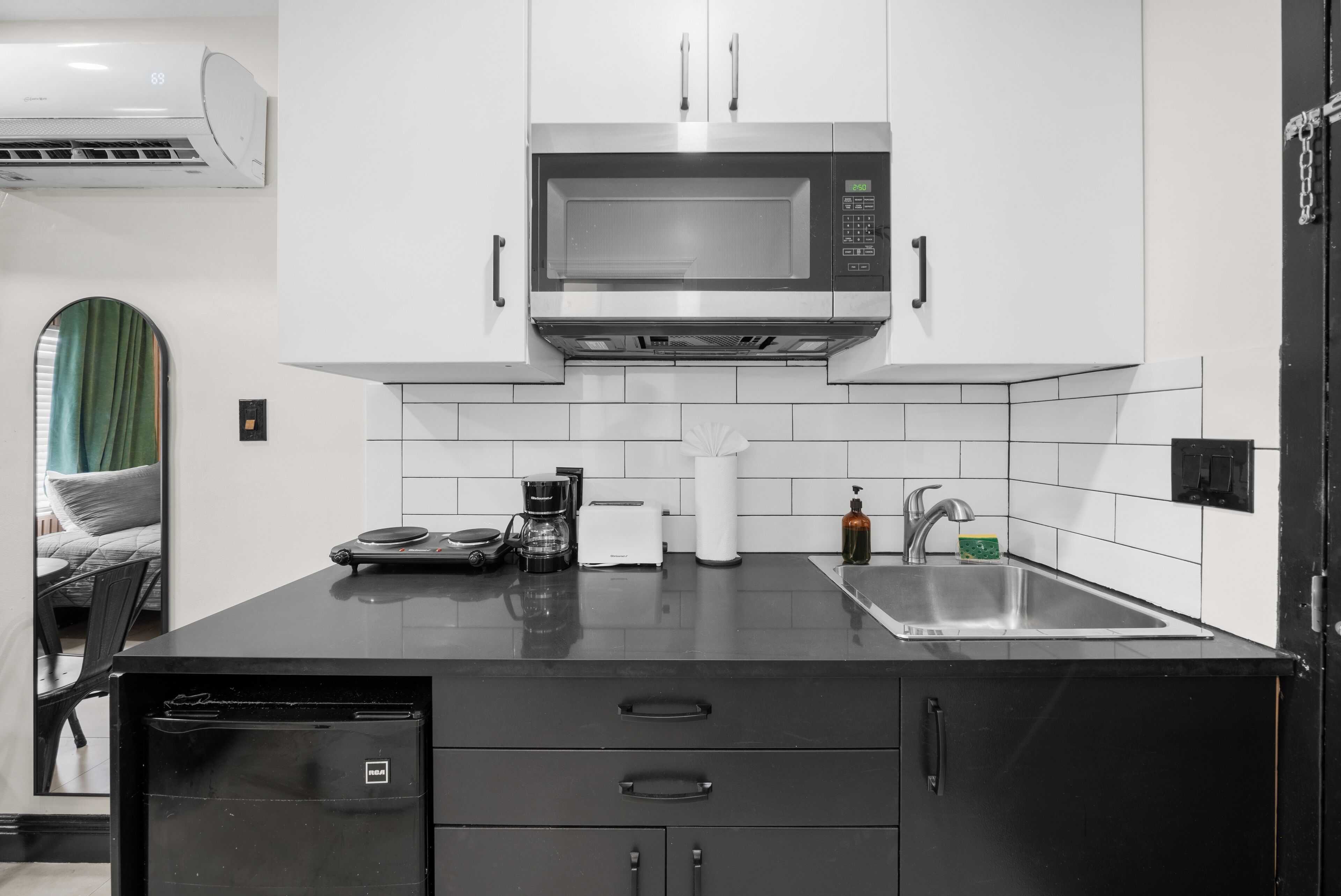 A modern kitchen with a microwave, coffee maker, and sink.