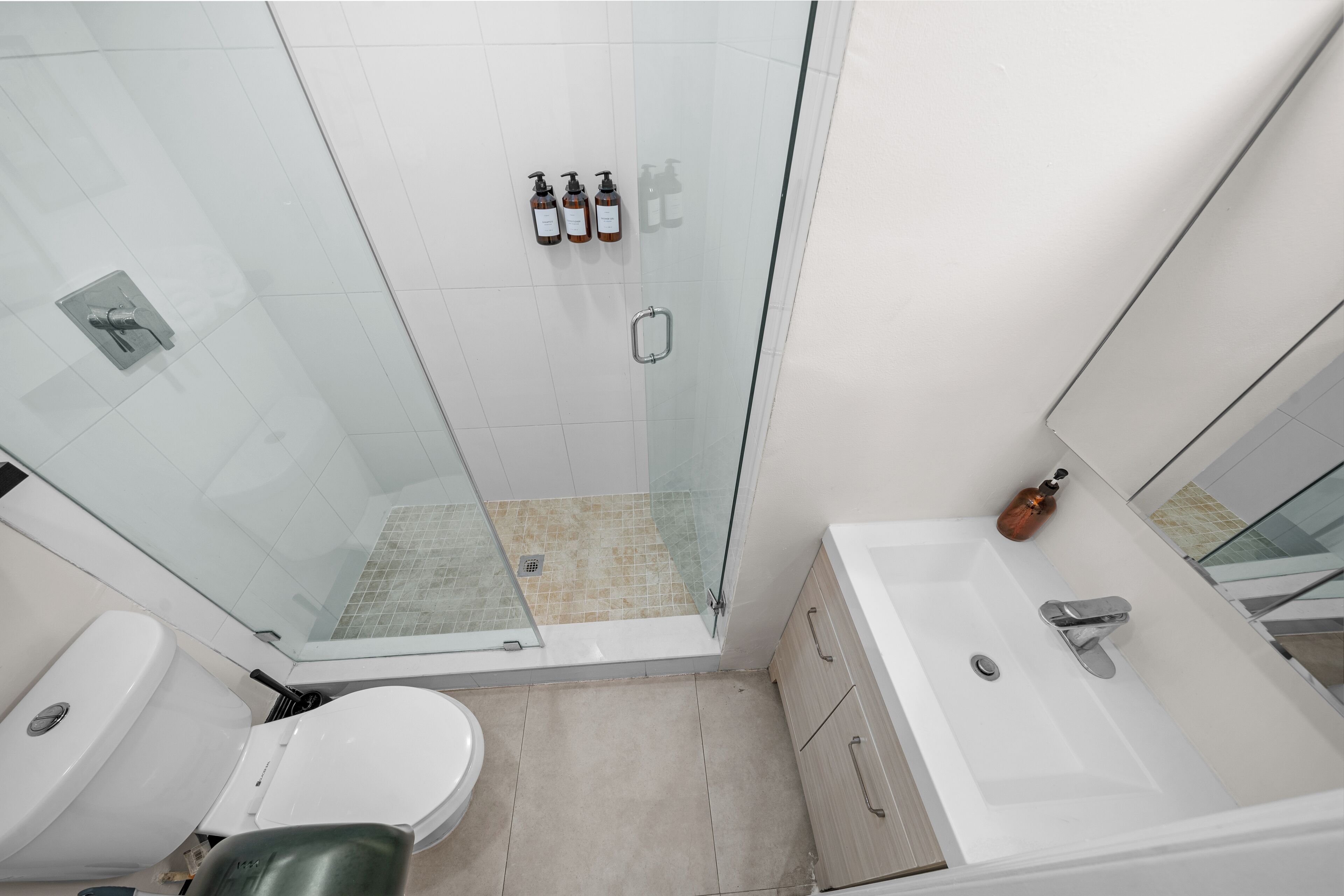 A modern bathroom with a glass shower enclosure, a white sink, and a bathtub.