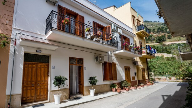 Un immeuble à deux étages doté de balcons, de plantes en pot et offrant une vue dégagée sur le paysage environnant.