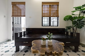 Relax in this serene living area with a comfortable bench, coffee table, and lush greenery.