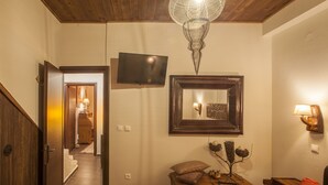 A hallway with a wooden ceiling, a television mounted on the wall, a mirror, and a table with decorative items. - Dandy Villas Palios Agios Athanasios |Rustic | Fireplace | Up to 6 (Agios Athanasios)