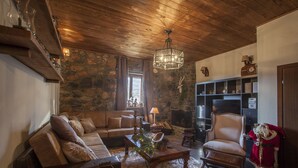 A cozy living room with a stone wall, wooden ceiling, a fireplace, a leather sofa, a wooden coffee table, and a Christmas tree. - Dandy Villas Palios Agios Athanasios |Rustic | Fireplace | Up to 6 (Agios Athanasios)
