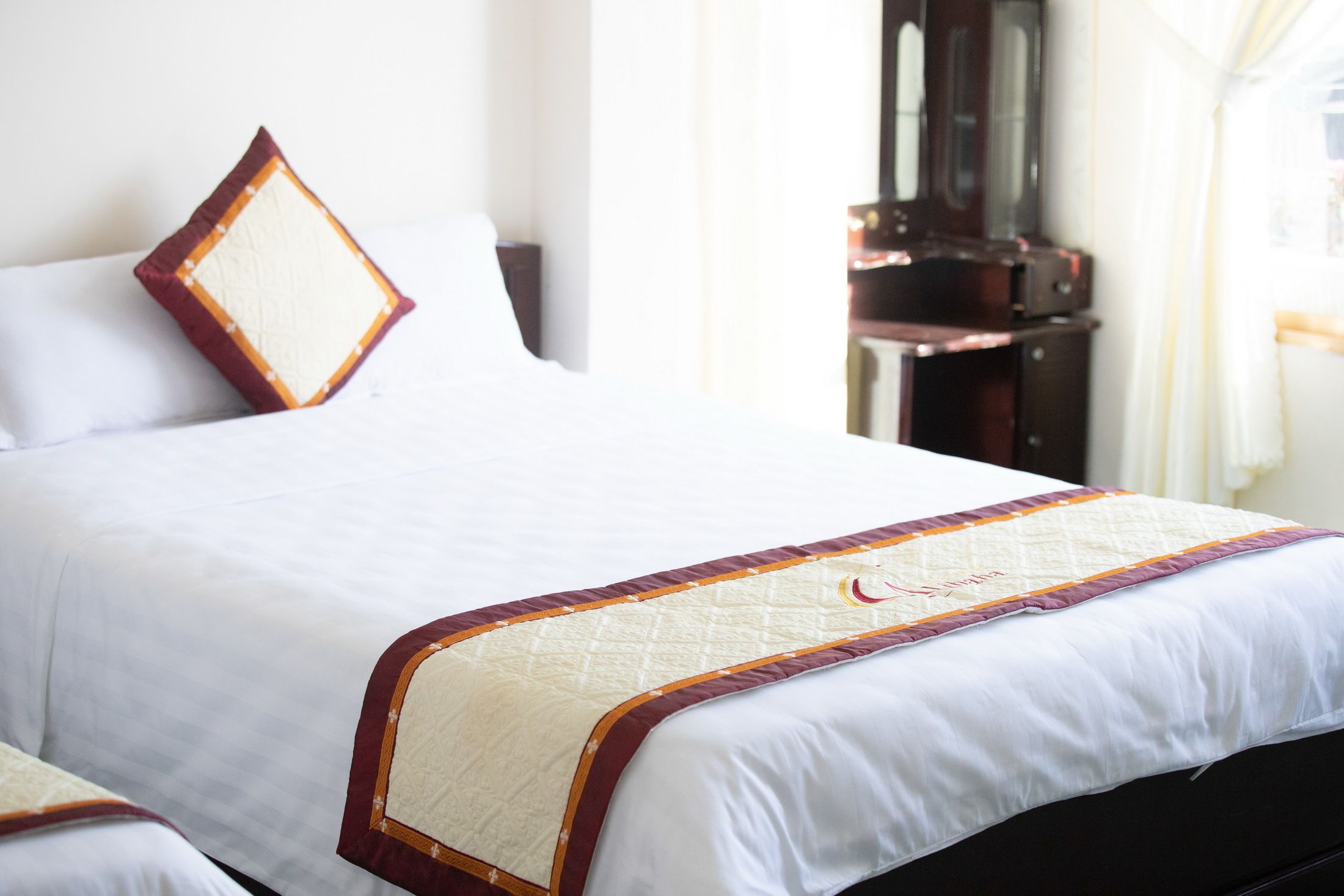 Un letto rifatto con copriletto trapuntato e cuscino decorativo.
