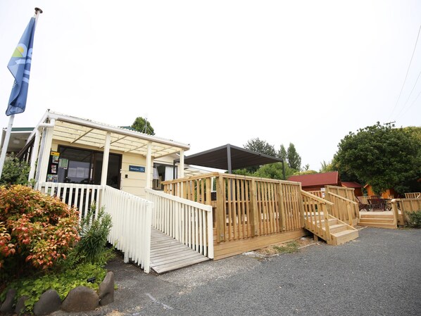 A reception area with a wooden fence, a covered walkway, and a flag.