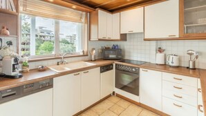 A modern kitchen with white cabinets, a built-in oven, and a dishwasher. - Baywatch Appartment close to the Airport at Porto Rafti 30 meters from the sea (Porto Rafti)