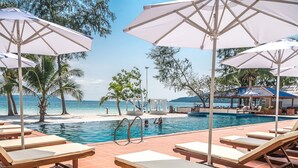 A poolside area with lounge chairs and umbrellas, a clear view of the beach, and a pool. - Scarlet Sails Resort (Koh Rong)