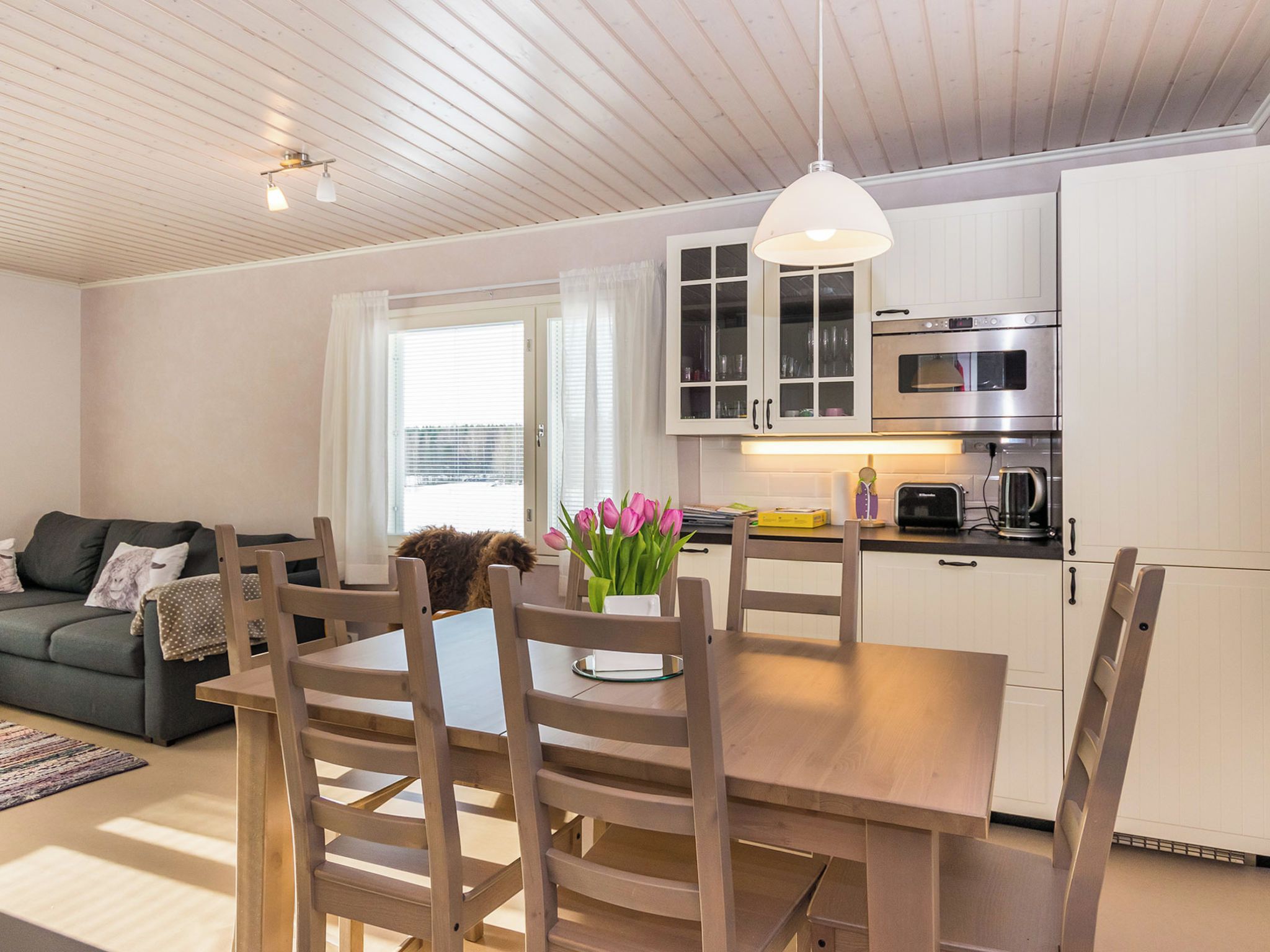 A modern kitchen with white cabinets, a microwave, and a toaster.